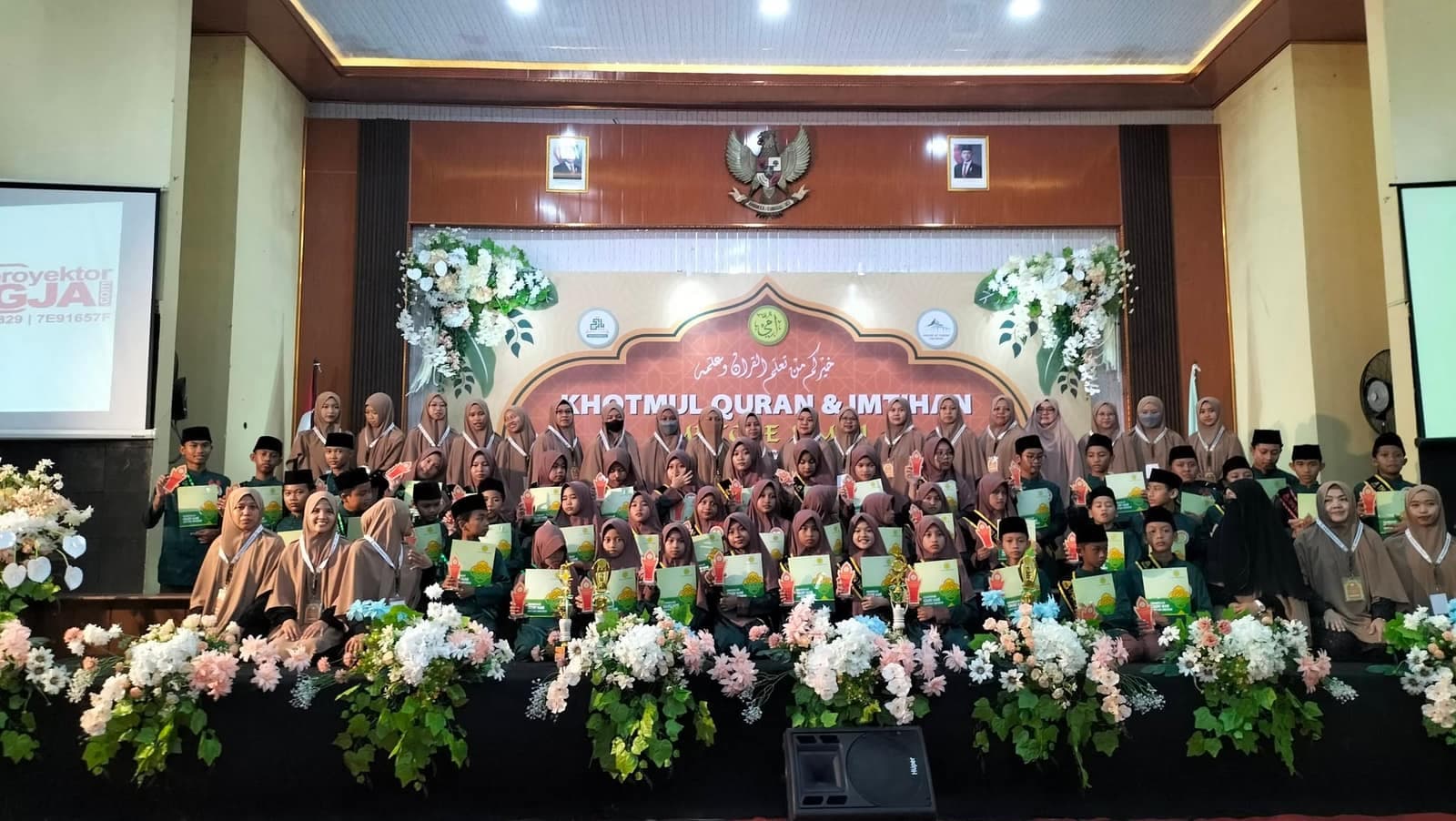 Wisudawan Khotmul Quran dan Imtihan berfoto di panggung