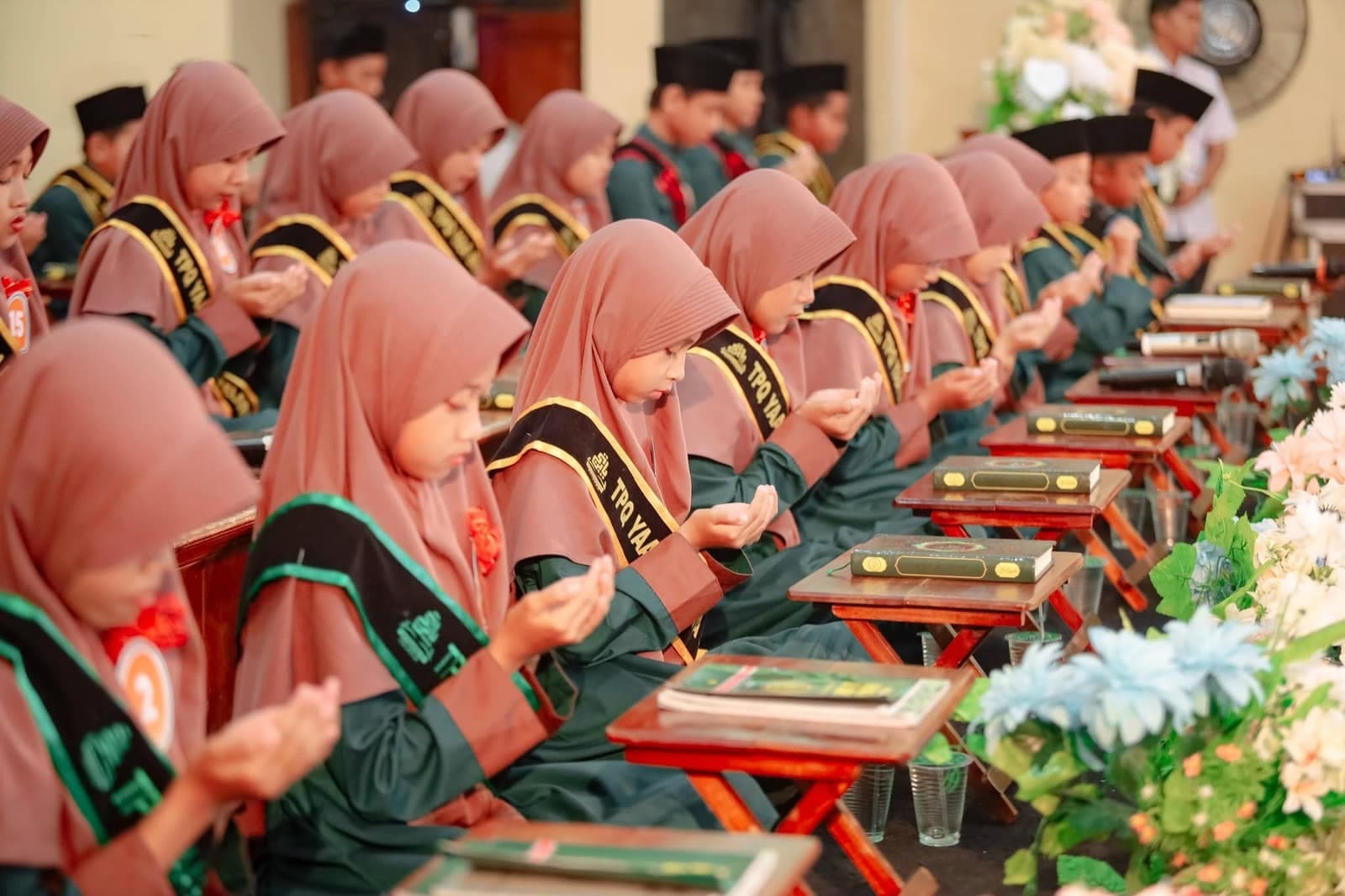 Santri berseragam hijau berdoa saat Khotmul Quran dan Imtihan