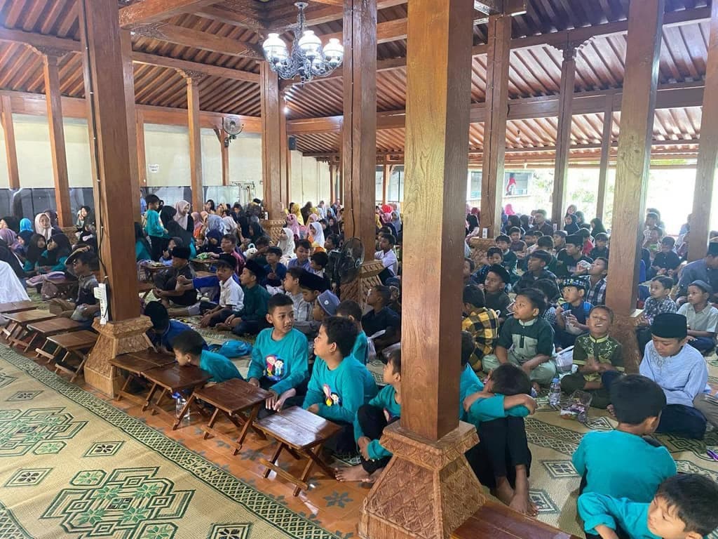 Santri putra belajar di meja lipat kecil di pendopo